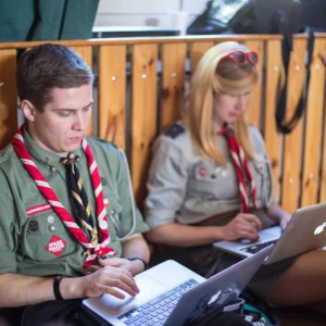 Dwoje instruktorów Związku Harcerstwa Polskiego siedzący z laptopami na kolanach ©ZHP / fot. Agnieszka Madetko-Kurczab